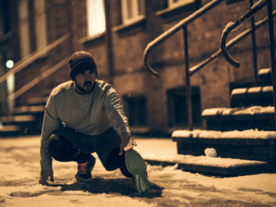 runner's high by running in cold weather - man stretching outside