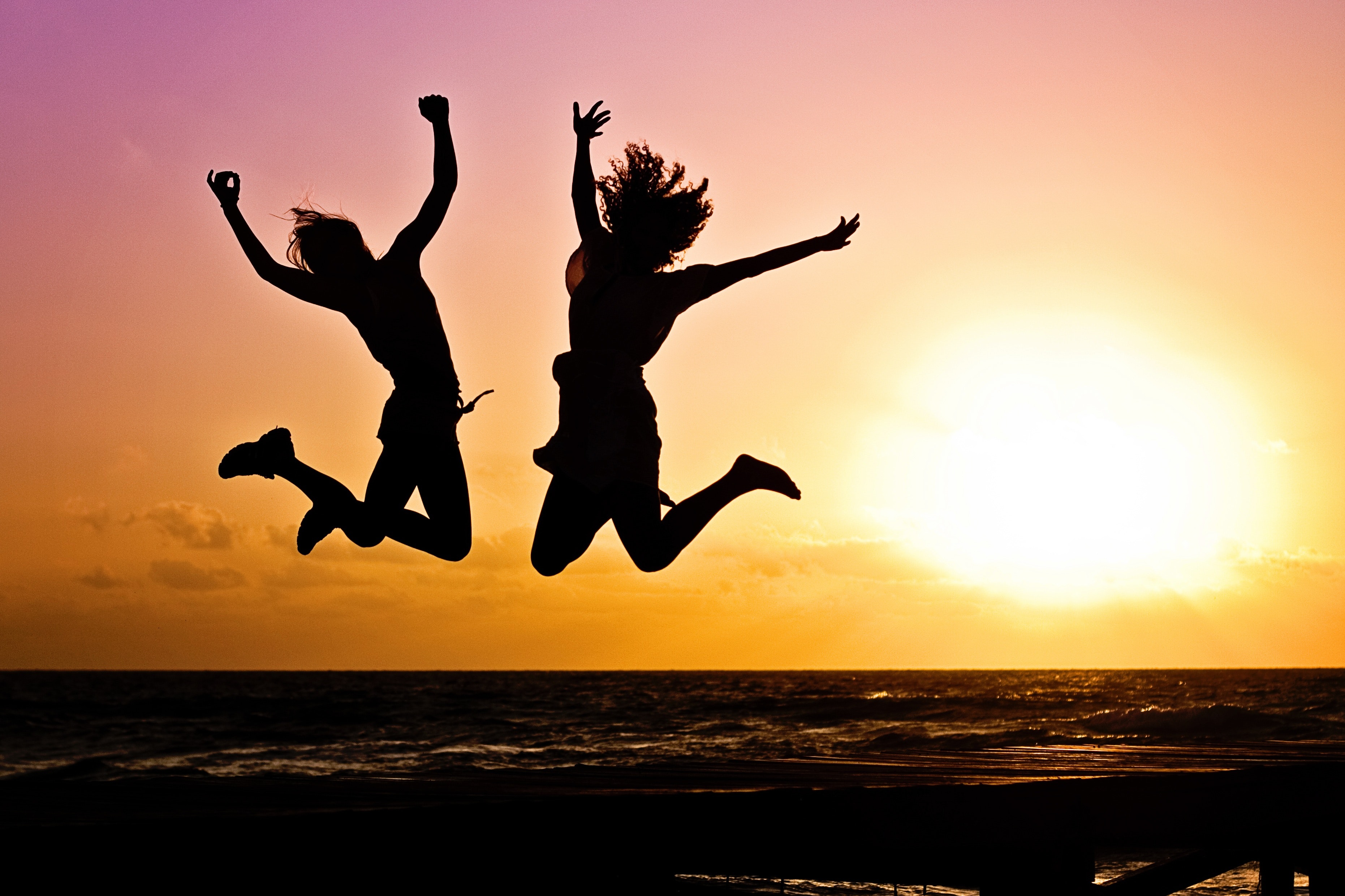 endorphins are generated in the body during exercise - happy people jumping at a beach